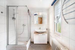 a white bathroom with a sink and a shower at Bungalow 71 in Stelzendorf +16 photos