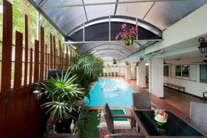 an indoor swimming pool with plants in a building at Nara Poshtel Sathorn in Bangkok