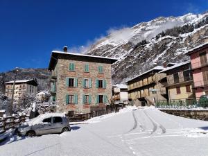 een auto geparkeerd in de sneeuw voor een berg bij Castori 1 in Prazzo +123 foto's
