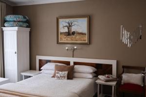 a bedroom with a bed and a picture on the wall at Aalkie's Dream in Swellendam