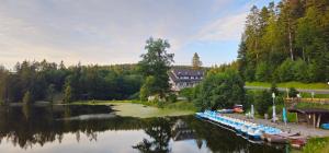 a river with boats parked next to a building at Schwaben Resort Ebnisee in Ebni
