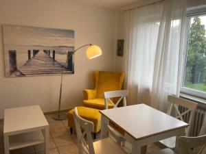a living room with a chair and a table at CUXKieker - Moderne Ferienwohnung mit Pep in Cuxhaven-Sahlenburg, WLAN, Parkplatz und Gartenblick, nah am Nordseestrand und Wernerwald in Cuxhaven