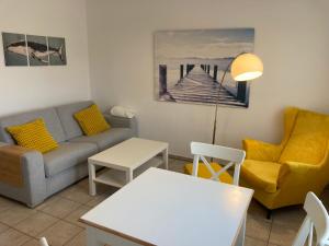 a living room with a couch and a table at CUXKieker - Moderne Ferienwohnung mit Pep in Cuxhaven-Sahlenburg, WLAN, Parkplatz und Gartenblick, nah am Nordseestrand und Wernerwald in Cuxhaven