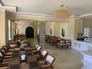 a restaurant with tables and chairs and a chandelier at Hotel crystal palace in Urganch