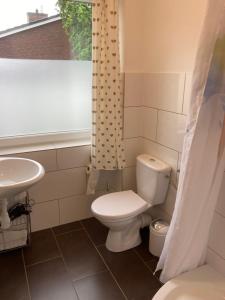 a bathroom with a toilet and a sink at CUXKieker - Moderne Ferienwohnung mit Pep in Cuxhaven-Sahlenburg, WLAN, Parkplatz und Gartenblick, nah am Nordseestrand und Wernerwald in Cuxhaven +17 photos
