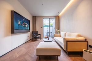 a living room with a couch and a tv at Yi Nian · Fangcun Hotel in Nanchang