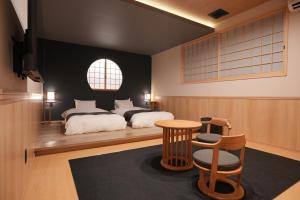 a bedroom with a bed and a table and chairs at LAKE villa CHITOSE in Hikone
