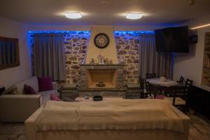 un soggiorno con camino e orologio sul muro di ΒΙΛΛΑ ΤΟ ΠΕΤΡΙΝΟ stone bild villa full equipment a Nafpaktos Altre 37 foto