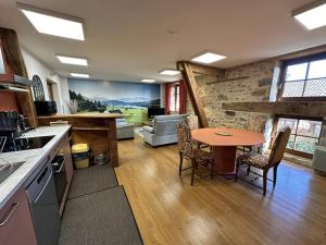 a kitchen with a table and a living room at La murette in Solignac