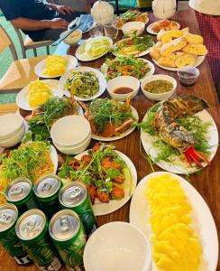 une table remplie d'assiettes de nourriture et de boissons dans l'établissement Tràng An Sunny River Homestay, à Ninh Binh