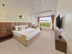 a bedroom with a large bed and a television at Empire By Zuper in Bhopal