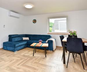 a living room with a blue couch and a table at Szarotka in Stronie Śląskie +24 photos