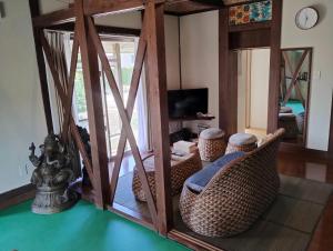 a living room with wicker chairs and a mirror at Unwind DAY OFF Nagamo in Yaese