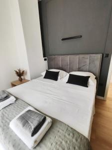 a large bed with white sheets and black pillows at Antoni Apartment in Lastovo