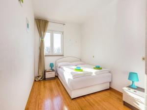 a bedroom with a white bed and a window at Contemporary Holiday Home in Dramalj with Swimming Pool in Dramalj +59 photos