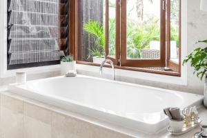 a white bath tub in a bathroom with a window at Cape Vue - Vue 2 Byron Bay in Ewingsdale