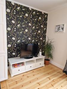 a living room with a tv on a wall at Rumianka in Rumia