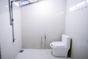 a white bathroom with a toilet and a shower at KLIA Transit Homestay Tun Fatimah in Banting +5 photos