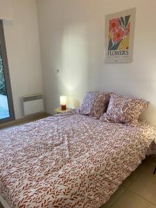 1 dormitorio con 1 cama grande y edredón en Appartement avec terrasse, en Nimes