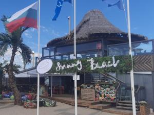 a sign in front of a sushi hut with flags at Guest House Paskal in Sunny Beach