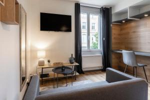 a living room with a couch and a table at Le VD - appartement T2 proche gare et centre-ville in Bourg-en-Bresse
