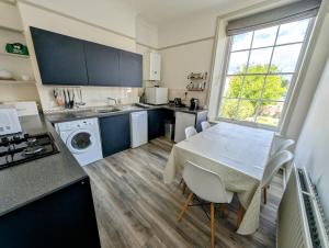 a kitchen with a table and a kitchen with blue cabinets at Eastgate Lodge Flat 23B in Pickering