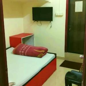 a room with a bed with a television and a pillow at Hotel Pine City in Shillong