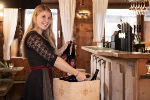 a woman is holding a box of wine at Hotel Alpenstolz - Culinary Hideaway Stubai in Mieders +39 photos