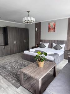 比什凯克Kausar Hotel的有两张床和一张桌子的酒店房间
