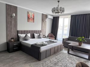 比什凯克Kausar Hotel的带一张大床和一张沙发的卧室