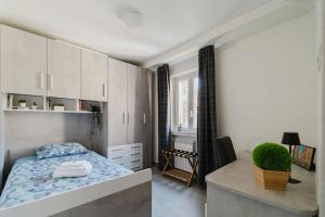 a bedroom with a bed and a desk in it at The Boutique Apartment in Parma