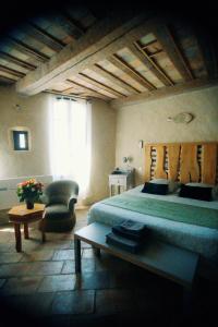 Un dormitorio con una cama, una silla y una mesa. en LA CASA DE BOULBON, en Boulbon 43 fotos más