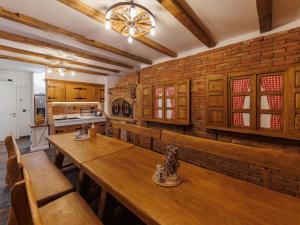 Una cocina con mesas de madera y una pared de ladrillo. en Villa Riva Vir I, en Vir