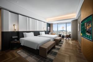 青岛MaxX by Steigenberger Harbour-view Qingdao的一间有两张床和一台电视的酒店房间
