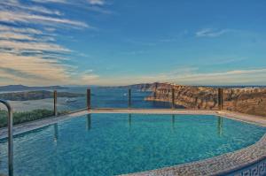 a swimming pool with a view of the mountains and water at Suites of the Gods Cave Spa Hotel in Megalokhori
