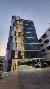 un edificio alto con molte finestre in un parcheggio di OK Hotel Bangkok a Bangkok