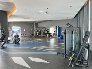 une salle de sport avec des tapis de course et des personnes en arrière-plan dans l'établissement Southville City homestay The Snug Spot 3 bedrooms Wifi Netflix, à Kampung Dengkil