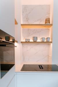 a kitchen with white marble counters and shelves at La Brise Marine in Ostend