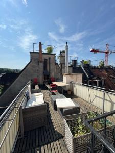 una azotea con bancos y mesas en un edificio en Rustic lakeside gem with rooftop looking to Zurich see, en Zúrich