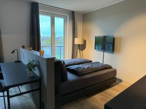 a living room with a couch and a large window at Exklusives Wohnen im historischen Wasserturm dem Highlight von Delitzsch WE318 in Delitzsch