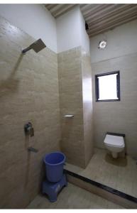 baño con ducha, aseo y ventana en Hotel KV Pride, en Mehekar