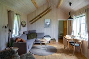 a living room with a couch and a table at Unstad cabin with seaview in Unnstad