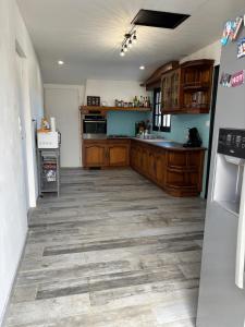 a large kitchen with wooden cabinets and a tile floor at Villa Perle Atlantique in La Vallée
