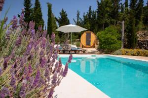 a swimming pool with an umbrella and a tent at Boo Premium Living Villen Auf Lefkada in Tsoukaladhes