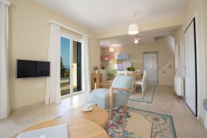 a living room with a table and a dining room at Boo Premium Living Villen Auf Lefkada in Tsoukaladhes