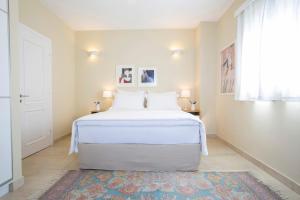 a white bed in a room with a window at Boo Premium Living Villen Auf Lefkada in Tsoukaladhes +32 photos