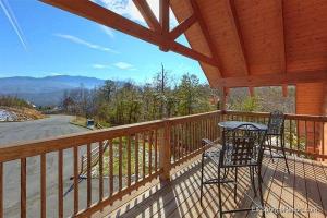 a deck with a table and a chair on a porch at Moonshiner's Legacy Holiday home in Gatlinburg