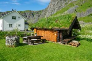 a house with a grass roof with a picnic table at Unstad cabin with seaview in Unnstad