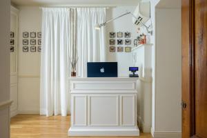 uma sala com uma mesa branca com um laptop sobre ela em Mabelle Centro em Florença