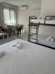 a room with three bunk beds and a table and chairs at Alex Studios Paralia Vrasna in Asprovalta